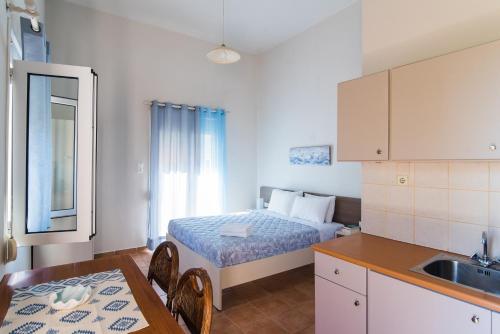 a room with a bed and a kitchen with a sink at Malia sea view in Pírgos