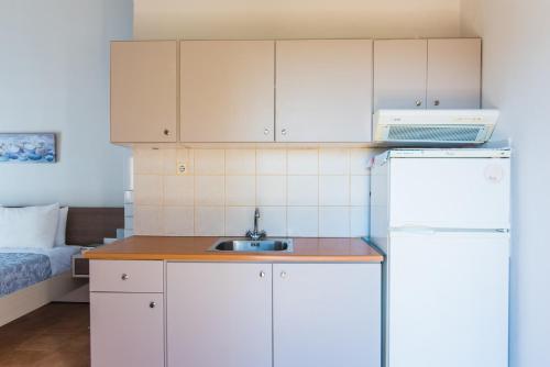 a kitchen with a sink and a refrigerator at Malia sea view in Pírgos