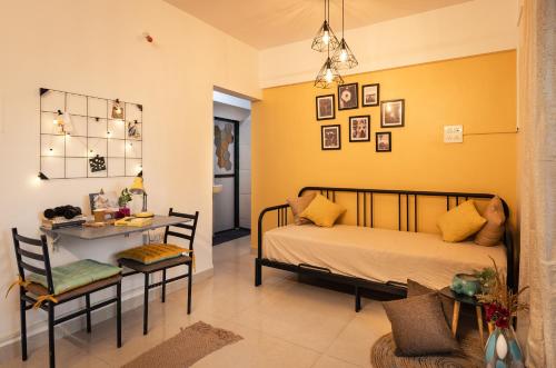 um quarto com uma cama, uma mesa e cadeiras em CollarCamp 1BHK Apartment em Nova Bombaim