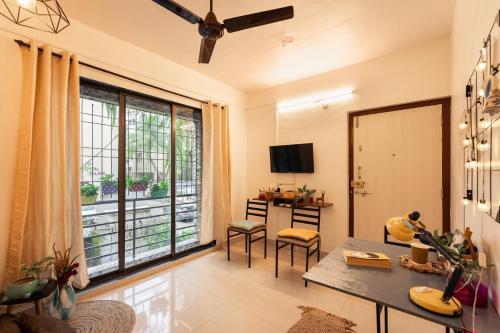 新孟買的住宿－CollarCamp 1BHK Apartment，客厅设有桌子和大窗户