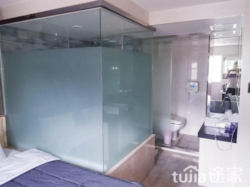 una camera con una doccia in vetro e un letto di Cube Hotel a Busan