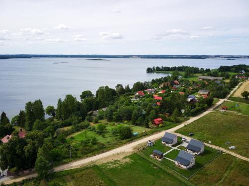 an aerial view of a village on the shore of a lake at M-MAZURIA Domki letniskowe całoroczne MAZURY GIŻYCKO - z sauną i jacuzzi Fuleda in Fuleda