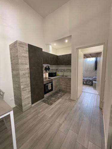 a large kitchen with wooden floors and a room with a bed at Da Lenny the Grey Apartment in Treviso