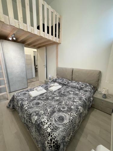 a bedroom with a bed with a black and white comforter at Da Lenny the Grey Apartment in Treviso