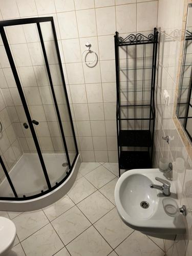 a white bathroom with a shower and a sink at Villa Marina in Dąbki