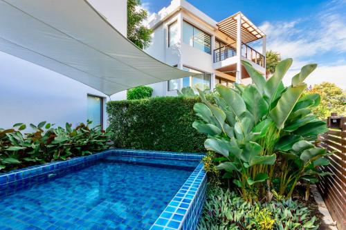 a swimming pool in front of a house at The Rock Hua Hin Beachfront Spa Resort - SHA Plus in Hua Hin