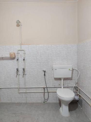 a bathroom with a toilet and a shower at Madrid Homes in Guwahati