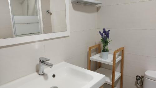 a white bathroom with a sink and a mirror at Balcon al mar in Bellreguart