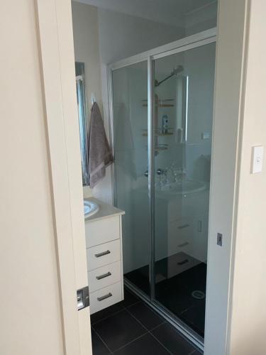 a bathroom with a glass shower and a sink at Private room with ensuite and parking close to Wollongong CBD in Wollongong