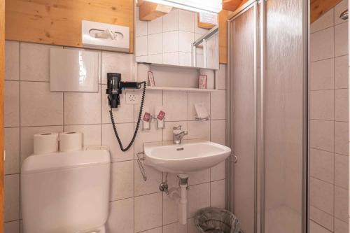 a bathroom with a toilet and a sink at Aktiv- und Genusshotel Alpenblick in Fiesch