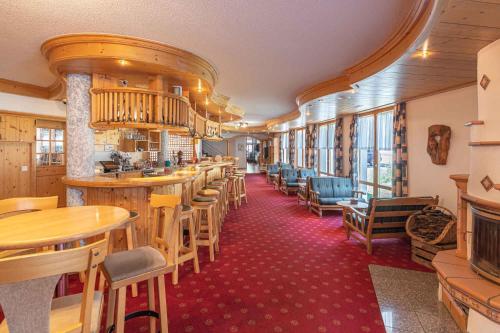 ein Restaurant mit einer langen Reihe von Tischen und Stühlen in der Unterkunft Aktiv- und Genusshotel Alpenblick in Fiesch