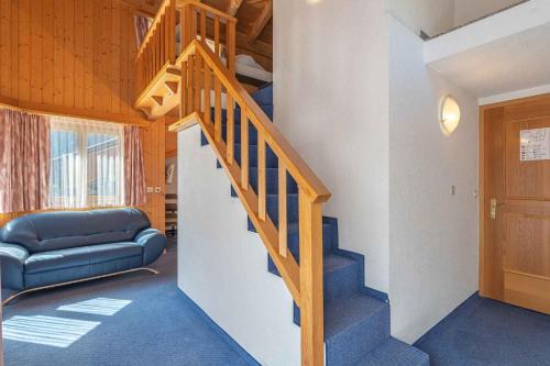 a wooden staircase in a room with a couch at Aktiv- und Genusshotel Alpenblick in Fiesch