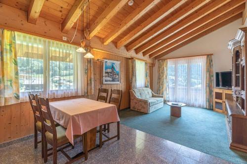 a dining room with a table and chairs and a television at Aktiv- und Genusshotel Alpenblick in Fiesch