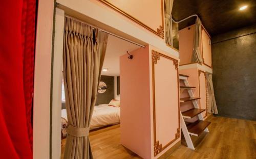 a room with a mirror and a bedroom with a bed at Lynlan Hostel & Cafe in Hat Yai