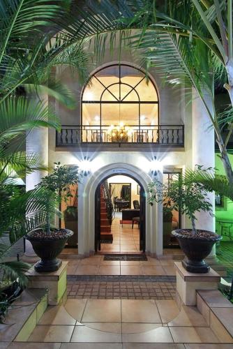 a hallway with palm trees in a building at Anchor's Rest Guesthouse and Self Catering in Durban