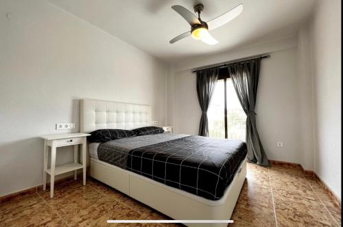 Beach Retreat في فالنسيا: غرفة نوم مع سرير مع مروحة سقف ونافذة