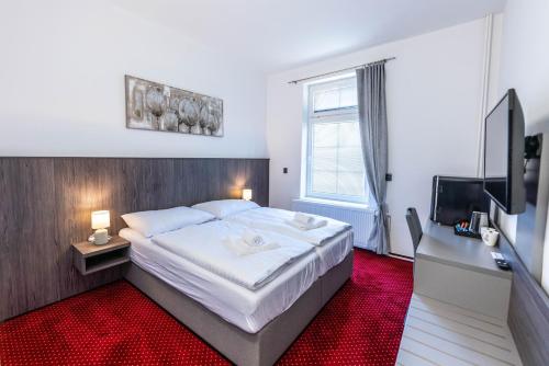 - une chambre avec un grand lit et un tapis rouge dans l'établissement Hotel Orka, à Moravská Třebová