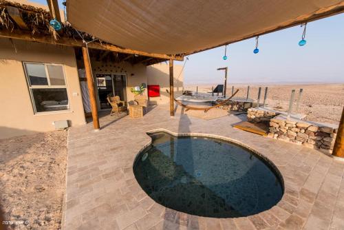 a house with a swimming pool in the desert at Arava Land in Zuqim