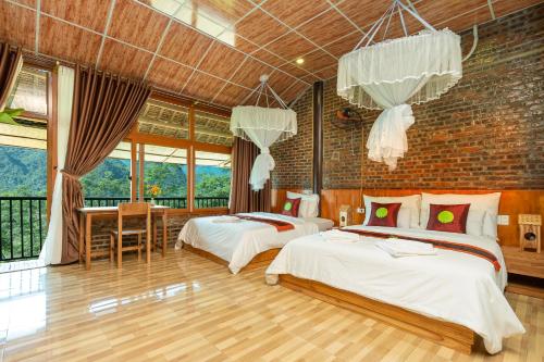 a bedroom with two beds and a brick wall at Inh La Home Pu Luong in Pu Luong