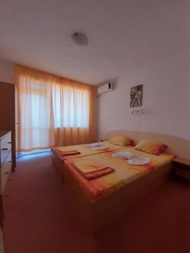 a large bed in a room with a window at Guest House Malkata Stopanka in Primorsko