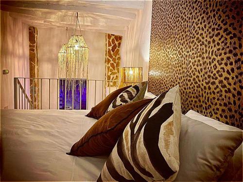 - une chambre avec un lit doté d'oreillers et d'un lustre dans l'établissement Mata Hari, à Inogés