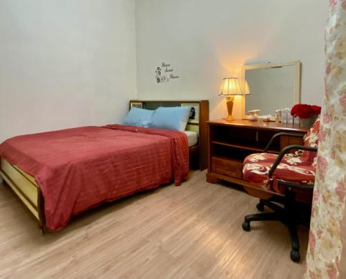 a bedroom with a bed and a desk and a mirror at Angel Spa Garden's Homestay in Ipoh