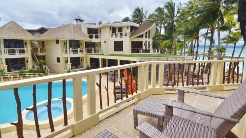 a balcony of a resort with two chairs and the ocean at Ambassador In Paradise in Boracay