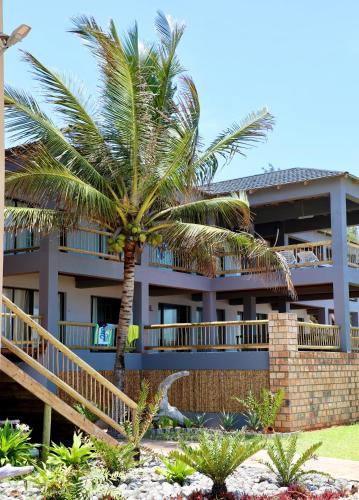 a palm tree in front of a building at Vista do Mar in Inhambane