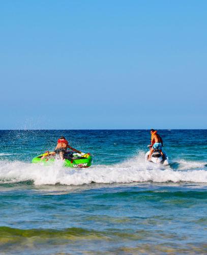 two people riding on a boat in the ocean at Vista do Mar in Inhambane