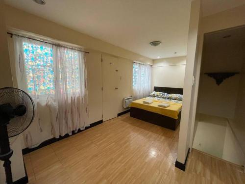 - une chambre avec un lit, une fenêtre et un ventilateur dans l'établissement Lovely home away from home, à Manille