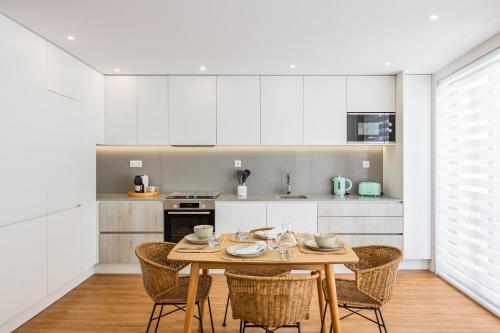 uma cozinha com uma mesa de madeira e cadeiras em Pestana Apartments - Premium no Porto