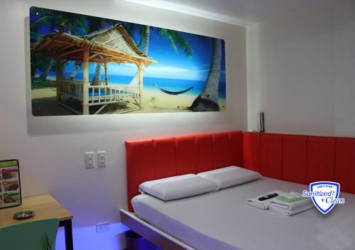 a bedroom with a red bed and a picture of a beach at My Inn Edsa Guadalupe in Manila