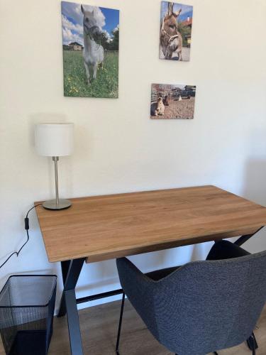 a desk with a lamp and pictures of horses on the wall at Pferdehof Thomayer in Strasswalchen