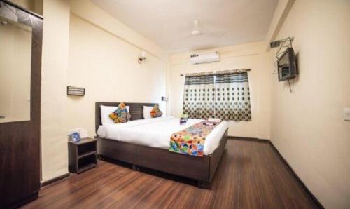 a bedroom with a large bed and a television at FabHotel East Field Homes in Pune