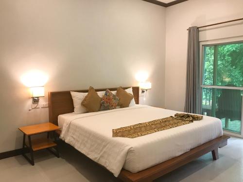 um quarto com uma cama grande e uma janela em Koh Yao Yai Sea Breeze House เกาะยาวใหญ่ซีบรีซเฮ้าส์ em Ko Yao Yai