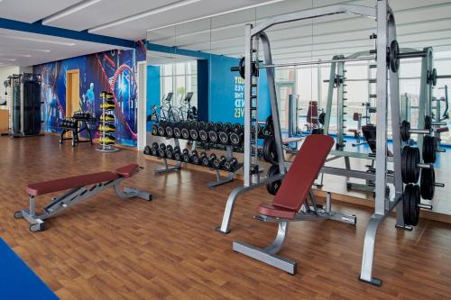a gym with treadmills and weights at Movenpick Jumeirah Village Triangle in Dubai