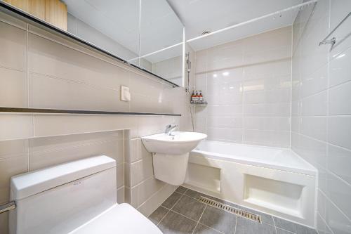 uma casa de banho branca com um WC e um lavatório em EdenStay em Geoje