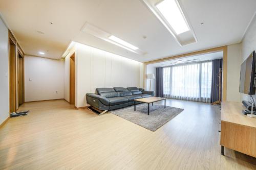 a living room with a couch and a table at EdenStay in Geoje 