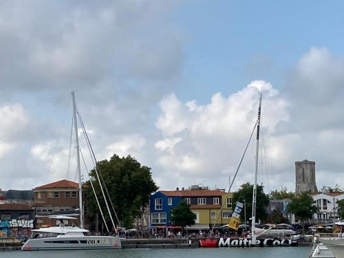 dos barcos están atracados en un puerto deportivo con edificios en La Rochelle Gabut Vieux Port superbe emplacement, en La Rochelle