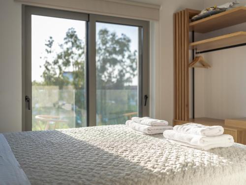 a bedroom with a bed with white towels on it at Allure Wellness Retreat in Lefkada Town