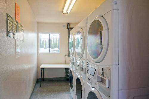 a laundry room with washing machines and a table at Castle Inn and Suites Anaheim in Anaheim