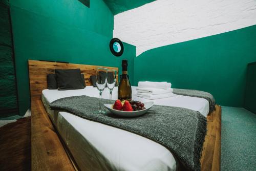 a room with two beds with a bowl of fruit and wine glasses at SPA SPA Letná in Prague