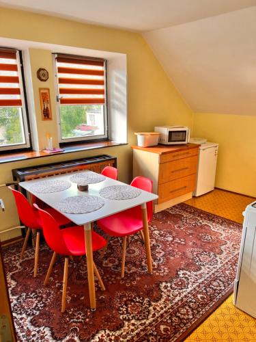 una pequeña cocina con mesa y sillas rojas en Na samotě u lesa, en Loučovice