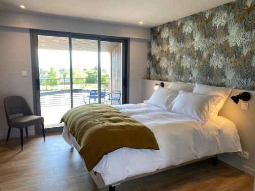 La Bellevue Bistrot et Chambres d'Hotes في Séné: غرفة نوم بسرير كبير عليها لوحة على الحائط