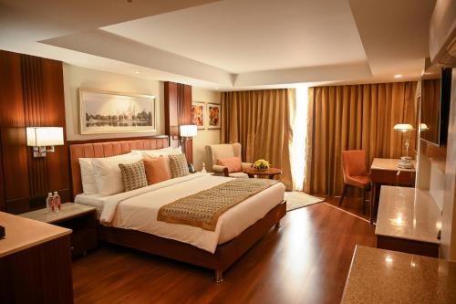 Habitación de hotel con cama y sala de estar. en Fortune Park Panchwati, Kolkata - Member ITC's Hotel Group, en Calcuta