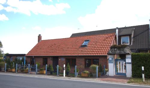 a brick house with a red roof on a street at "Alte Schmiede" in Nordenham