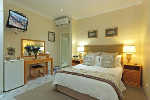 a bedroom with a bed and a tv on the wall at Anchor's Rest Guesthouse and Self Catering in Durban