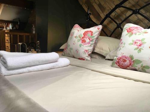 1 cama con 2 almohadas y toallas en The Hideaway, en Ripponden