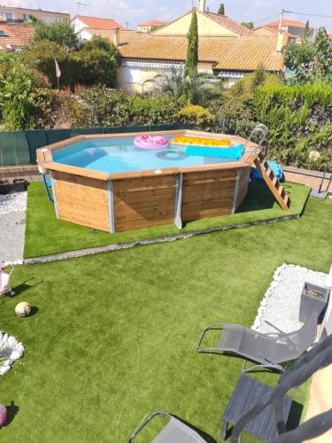 une piscine dans une cour avec une pelouse sidx sidx sidx dans l'établissement Chez Manon et Jimmy, à Agde