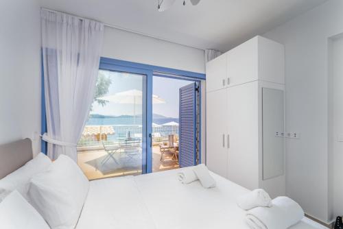 a bedroom with a bed and a large window at Greek Beach House B2 Lefkada in Nydri